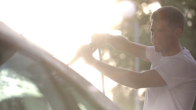 Man in a white t-shirt washes white car Slow motion