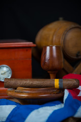 Cuban cigar in ashtray with humidor and rum barrel