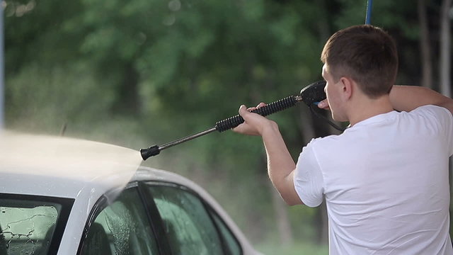 Man in a white t-shirt washes white car Slow motion