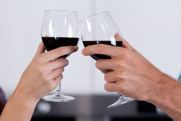Couple's hands holding glasses of wine