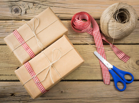 parcels wrapped in brown paper and string with ribbon and scisso