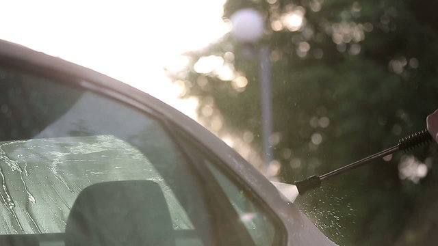 Man in a white t-shirt washes white car Slow motion