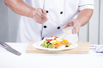 Chef putting salad dressing