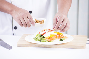 Chef sprinkle biscuits on Salad