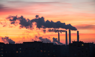 Fototapeta na wymiar Power Plant emissions from a city during sunrise.