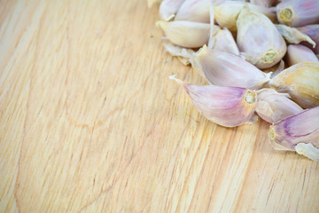 garlic cloves on wood cutting board