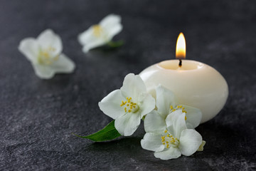 Obraz na płótnie Canvas Jasmine flowers and burning candles for spa on a black