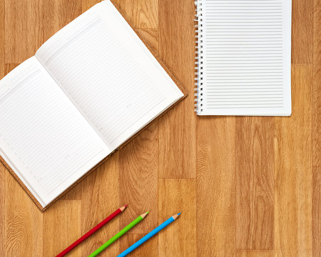 Blank notepad with office supplies on wooden table.