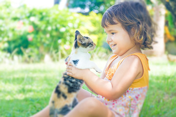 outdoor portrait of young child girl with small kitten, girl pla