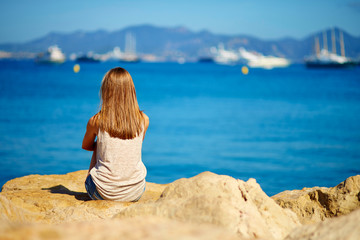 Young girl sitting on the sea shore