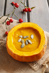 Creamy pumpkin soup on rustic wooden table