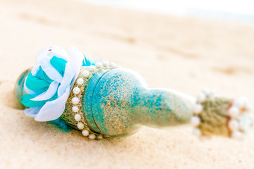 Fototapeta na wymiar glass bottle with colored sand on natural background, sand cerem