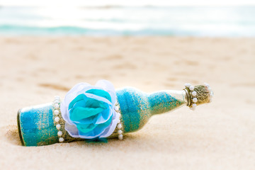 Fototapeta na wymiar glass bottle with colored sand on natural background, sand cerem