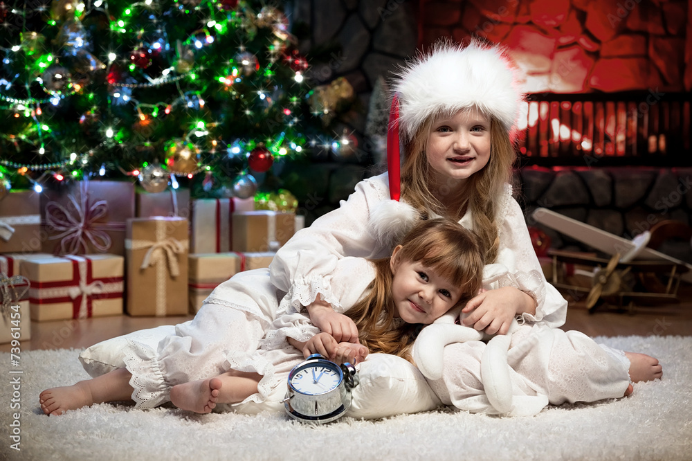 Sticker portrait of children under the christmas tree by the fireplace