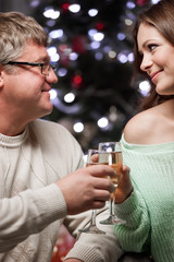Young couple with glasses of champagne meet Christmas