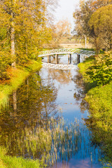 The clouds and the bridge reflected  in the pond