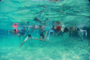 Group of young friends swim diving underwater