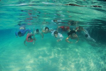 Naklejka na ściany i meble Group of young friends swim diving underwater