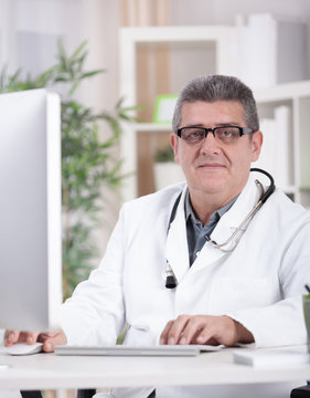 smiling modern senior doctor with glasses in the office