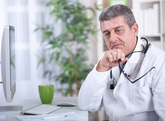 serious  modern senior doctor with glasses in the office