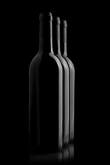 Three elegant wine bottles in a black background