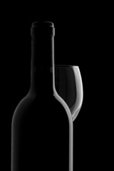 Elegant wine bottle and wine glass in a black background