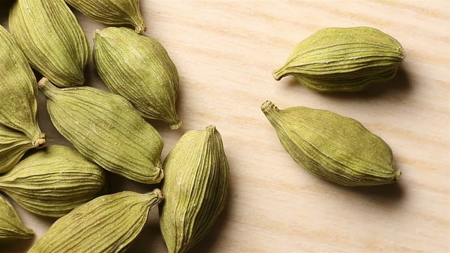 Cardamon seeds come out of the darkness. Moving shadows.
