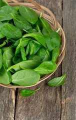 spinach in a basket on wooden surface