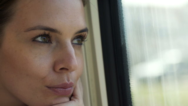 Face of woman looking through the window during train ride