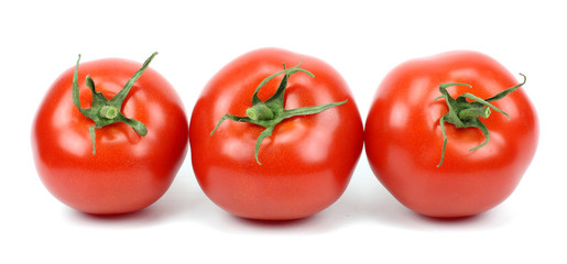 three fresh tomatoes with green leaves