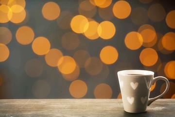 Cup of hot drink on bright background