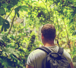 Tourist with backpack in the jungle. Vintage effect.