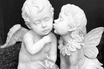 Fototapety  kissing couple of angelic figurines  isolated on dark background