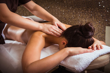 Masseur doing massage on woman body in the spa salon.