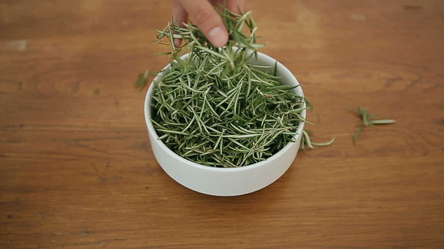 Bowl with rosemary on a wooden table