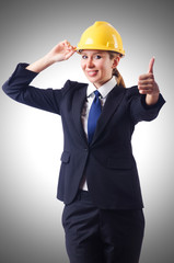 Young businesswoman with hard hat on white