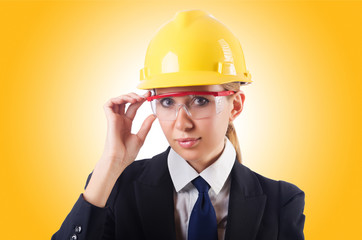 Young businesswoman with hard hat on white