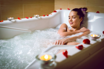 Obraz na płótnie Canvas young beautiful brunette woman takes bubble bath