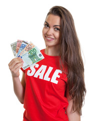 Dunkelhaarige Frau mit Sale-Shirt und Geldscheinen