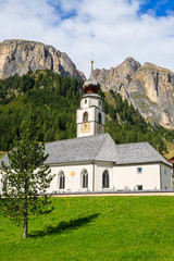 Fototapeta na wymiar Church in alpine village of Colfosco, Dolomites Mountains, Italy