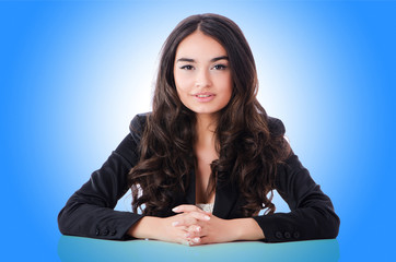 Young businesswoman sitting at desk on white