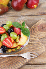 fresh tasty fruit salad on wooden table