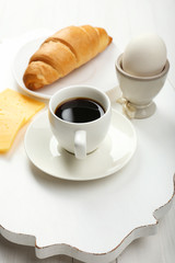 Delicious breakfast with coffee, fresh croissant, egg and