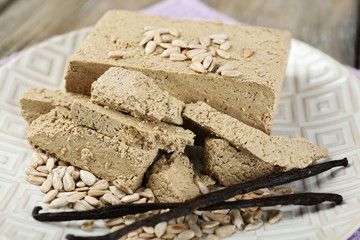 Sunflower halva on plate, on wooden background