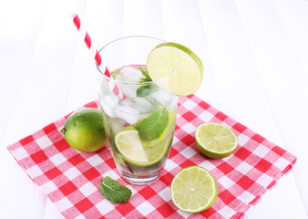 Lemonade in glass on napkin on bright background