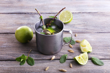 Lemonade in metal cup on wooden background