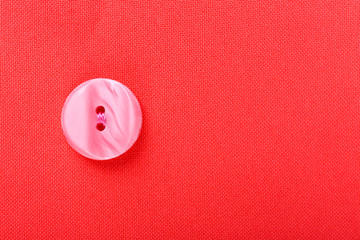 Button on red cloth, close up