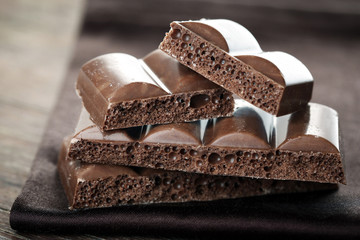 Tasty porous chocolate on wooden table