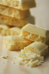 Tasty white porous chocolate on wooden table, close up