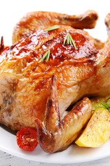 Delicious baked chicken on plate on table close-up